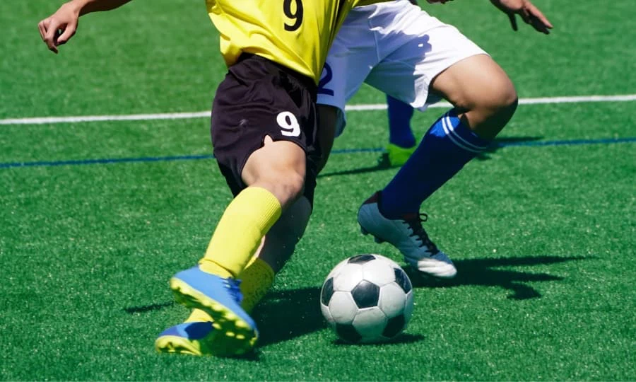Playing soccer on a soccer field Playing soccer on a soccer field